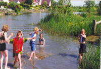 Kinderen spelen op een educatieve natte brug dicht bij het levende water